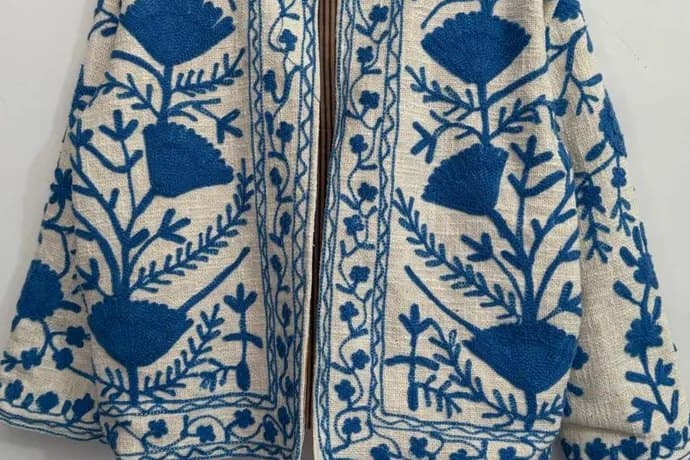 An ivory Suzani jacket with deep blue floral embroidery