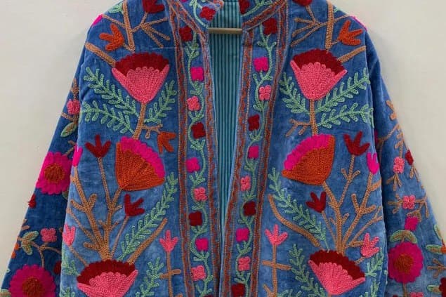 Close view of pink and red embroidery on cornflower blue velvet