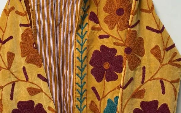 Back view of a black Suzani coat with dense multicoloured embroidery